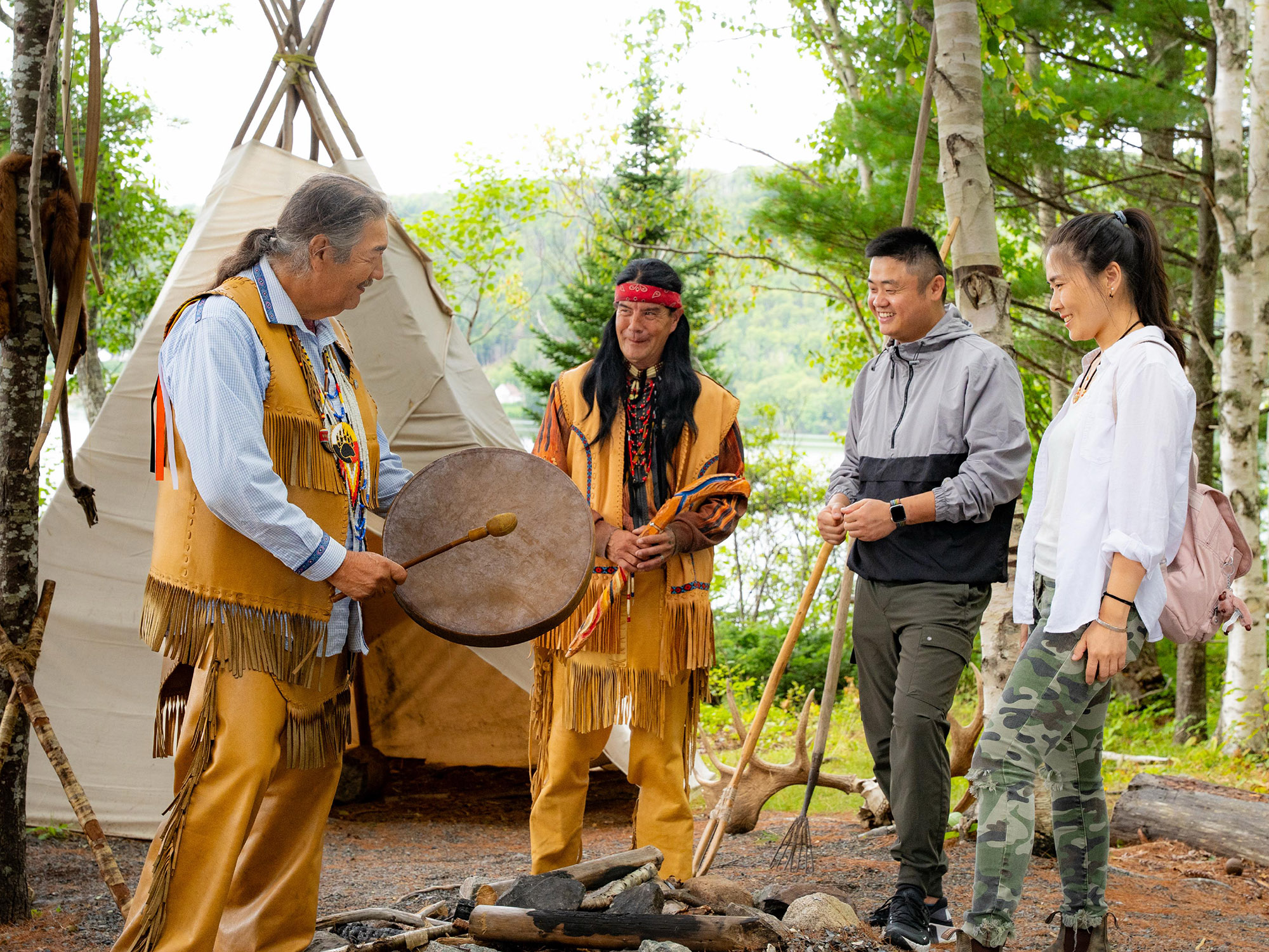 Two Mi'kmaw interpreters sharing their culture and history with two visitors taking part in the immersive experience on Goat Island with Eskasoni Cultural Experience in Cape Breton Nova Scotia.