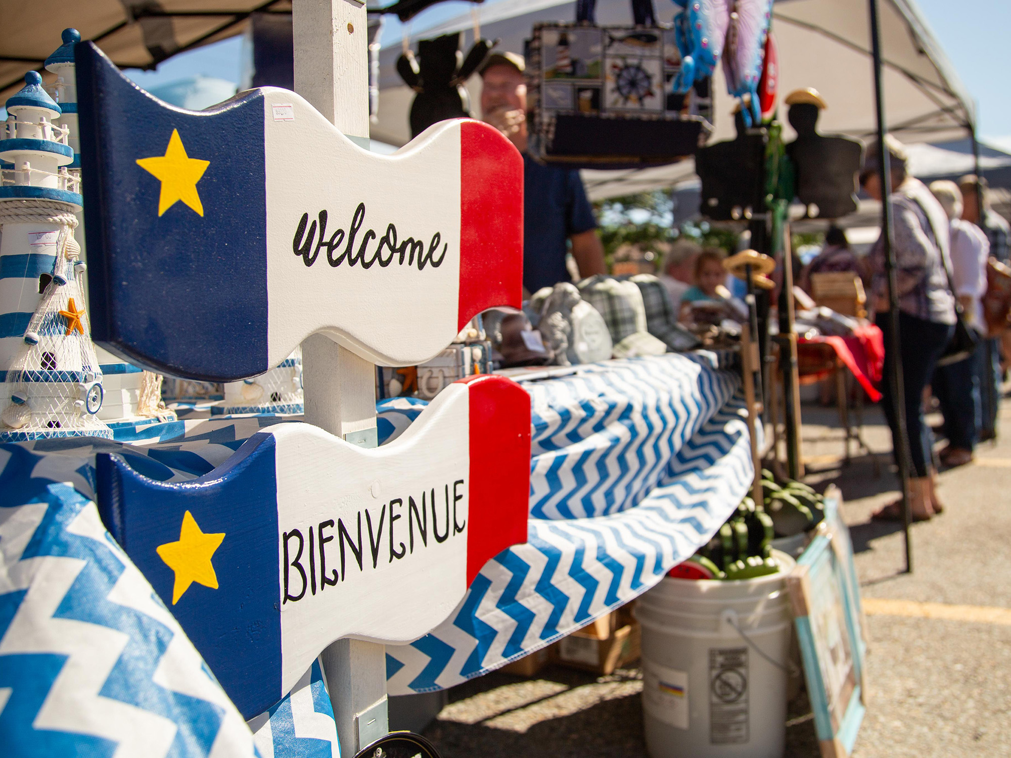 Acadian wooden signs that read 'Welcome' and 'Bienvenue'.