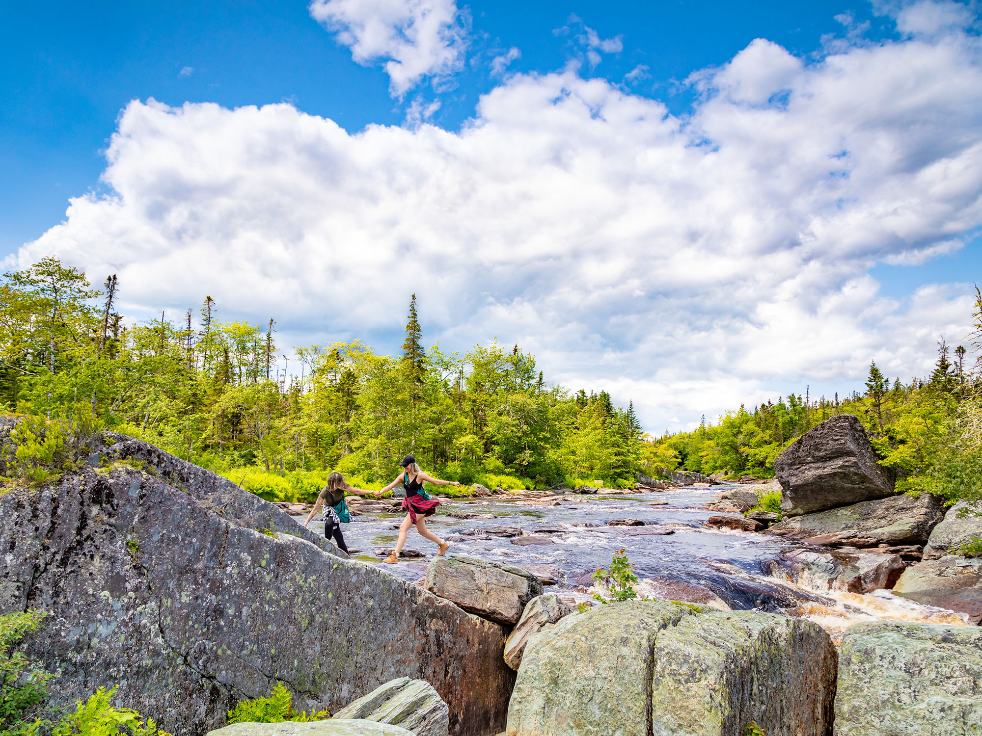 Two women hiking and walking through the water at Liscombe Lodge.