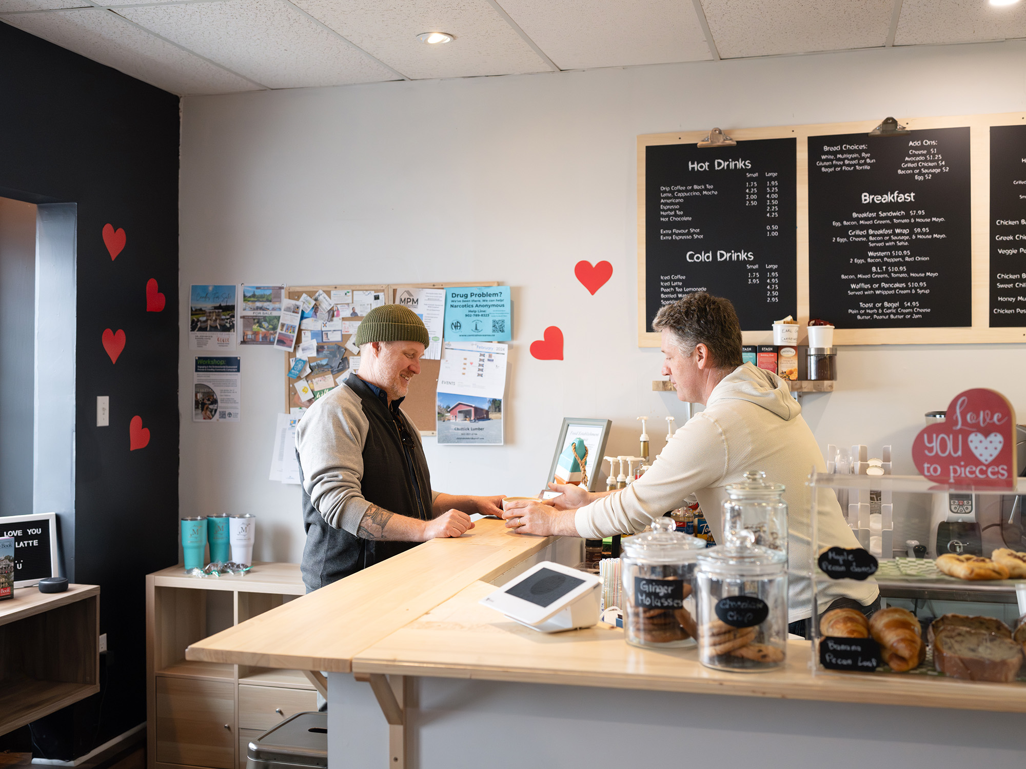 A man buying coffee and laughing with the barista at The Marmalade Motel